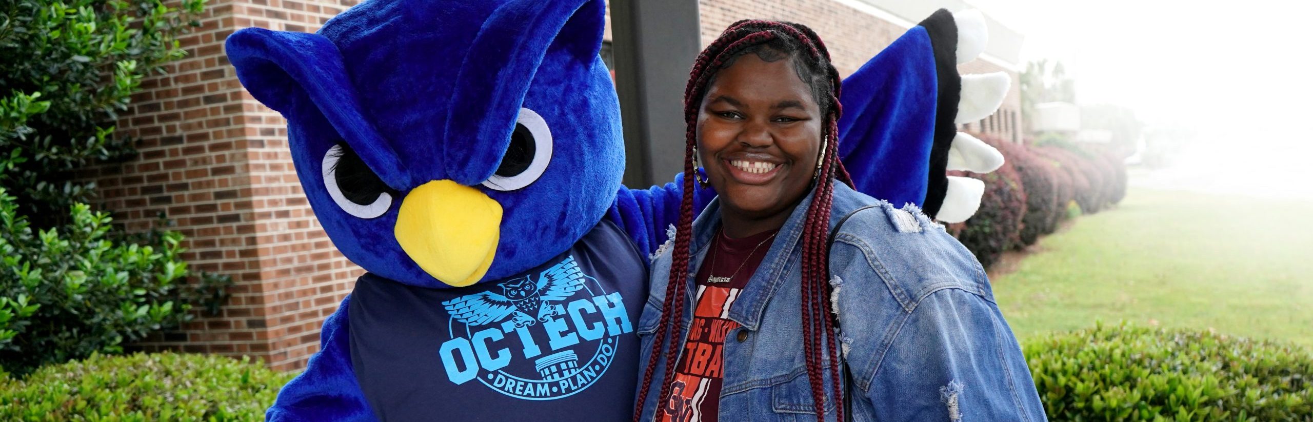 student with OCtech mascot Otus the Owl