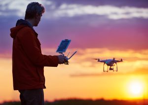 Man operating a drone at sunset