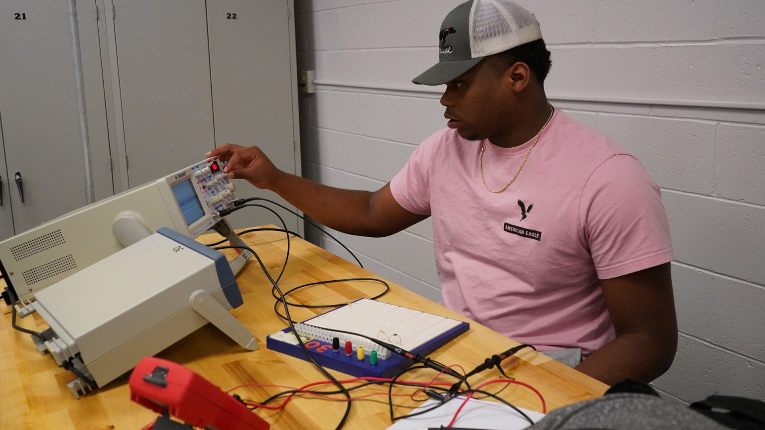 Male student working with electronic testing equipment