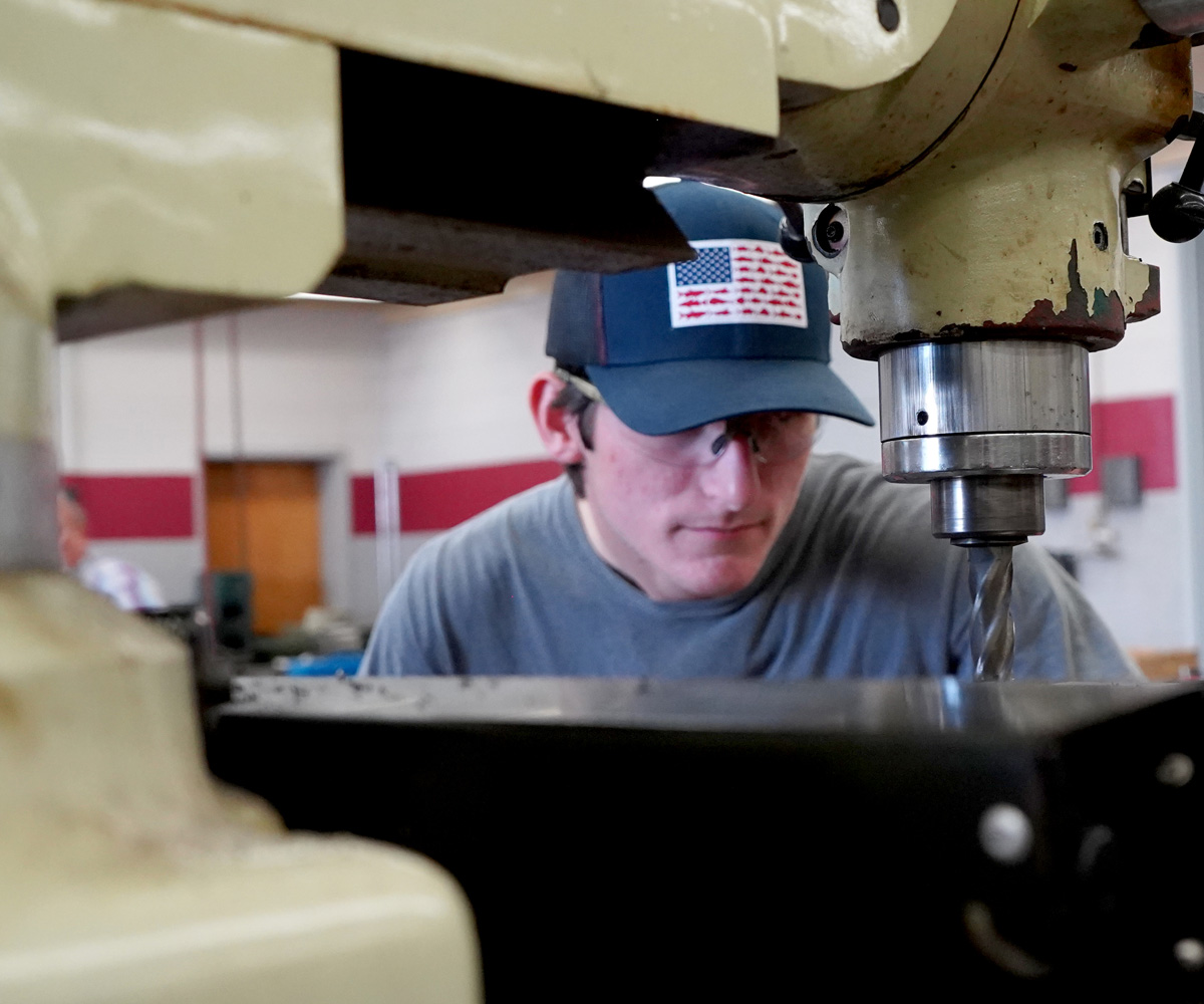 MTT student looking through drill press