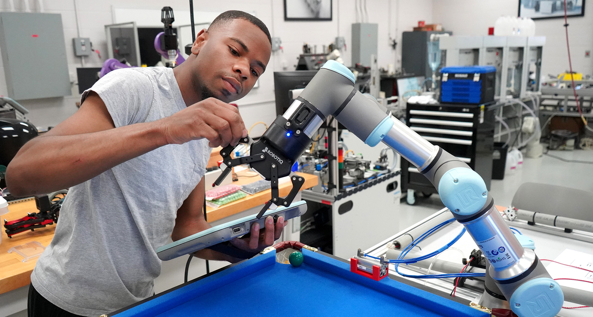 Mech student in lab with robot