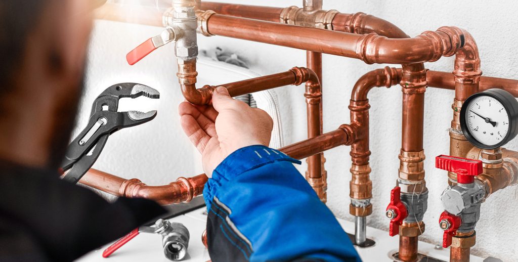 plumber's hand working on pipes