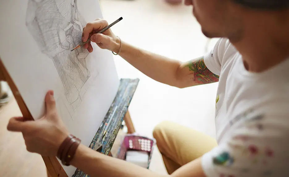 man drawing on easel